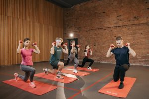 Indoor group workout session with dumbbells focusing on strength and fitness.